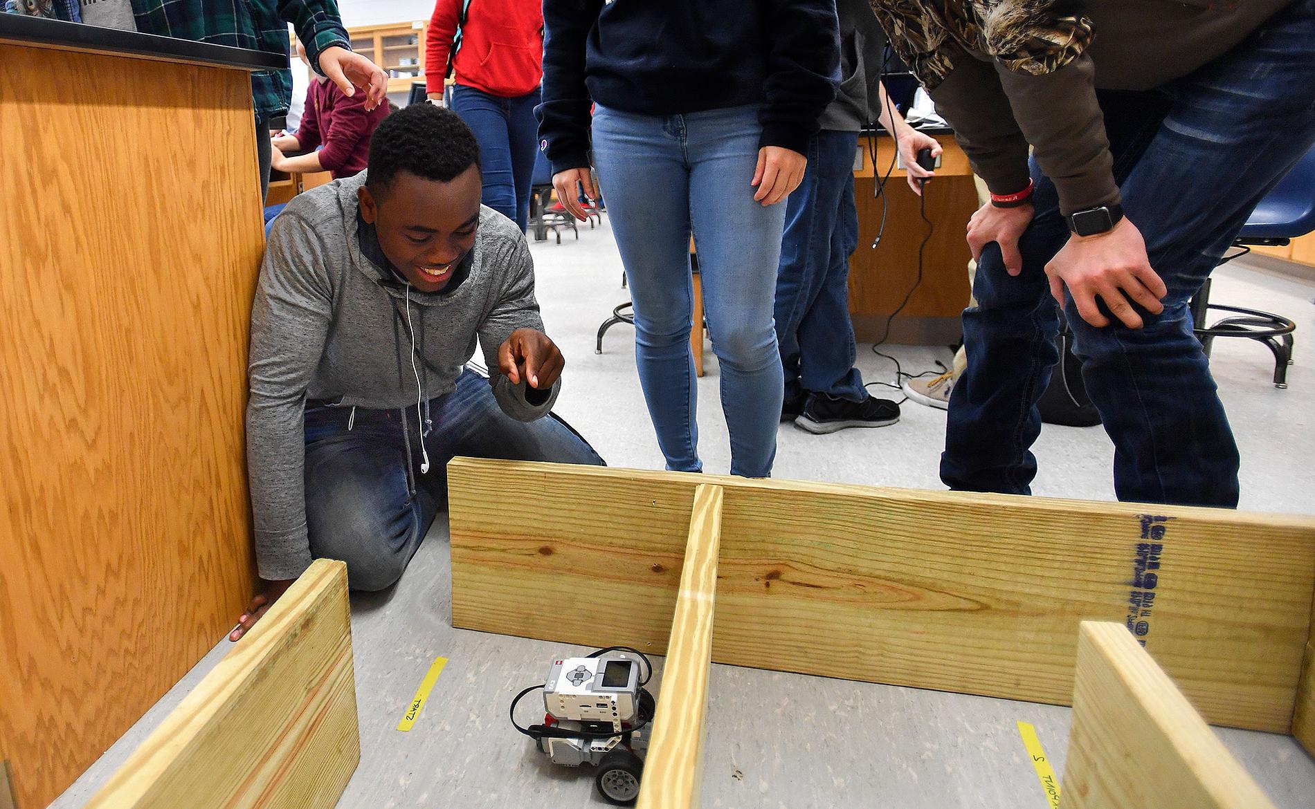 学生驾驶机器人穿过木制迷宫